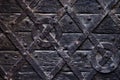 Old medieval wood background texture. Ancient and worn surface of wood from an old medieval door with rivets,rough texture wall. Royalty Free Stock Photo