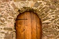 An old, medieval wooden door in a wall of bricks