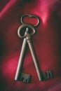 Old medieval wrought iron keys on red background