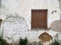 Old Mediterranean house outer wall with window, closed shutters with peeling paint Royalty Free Stock Photo