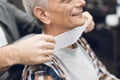 The old man is sitting in the barber`s chair in a man`s barbershop, where he came to cut his hair. Royalty Free Stock Photo