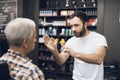 The old man is sitting in the barber`s chair in a man`s barbershop, where he came to cut his hair. Royalty Free Stock Photo