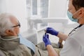 Old man patient have a check appointment at dental clinic the dentist doctor examining the teeth doctor using dental Royalty Free Stock Photo