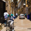 LECCE, ITALY APRIL 23, 2018 Senior men ride bicycle on the street in centre of Lecce