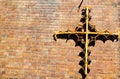 Old metal antique design christian cross attached on the red brick wall. Royalty Free Stock Photo