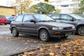 Old vetran metal brown small youngtimer Toyota Corolla compact two door parked