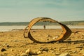 Old metal bucket on the beach and child behind it