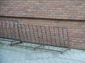 Old metal bycicle holder in front of school. Royalty Free Stock Photo