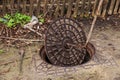Old metal cast iron canal hatch. Dangerous open unsecured hatch on the road. A broken iron manhole cover opened dangerously in Royalty Free Stock Photo