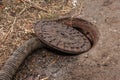 Old metal cast iron canal hatch. Dangerous open unsecured hatch on the road. A broken iron manhole cover opened dangerously in Royalty Free Stock Photo