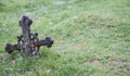 Ancient metal christian cross on green grass