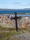 An old grave marker by a stacked stone wall at Nesseby Church in Northern Norway Royalty Free Stock Photo