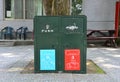 Old metal dark green bins located in a public place for different garbage recycling and general trash