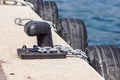 Old metal dock mooring pole with ring and rope for securing fishing boats Royalty Free Stock Photo