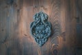 Old metal door handle knocker on a rough wooden background. Ancient door patina dark blue metal knocker of old family house. Royalty Free Stock Photo