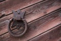 Old metal door handle knocker on a rough wooden background Royalty Free Stock Photo