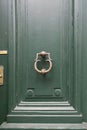 Old metal door handle lock on green wooden door. Door knob,  door knocker Royalty Free Stock Photo