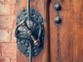 Old metal doorknob on the old wooden door, selective focus. Vintage forged padlock and door handle Royalty Free Stock Photo