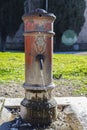Old metal fountain with open faucet Royalty Free Stock Photo