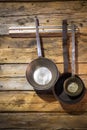 Old metal frying pans hanging on wooden wall Royalty Free Stock Photo