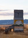 Old Metal Grain Elevator in Wyola, Montana, with Mountains in the Background and Dried Grass in Foreground Royalty Free Stock Photo