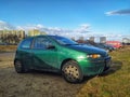 Old metal green dirty popular compact car Fiat Punto parked