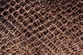 Old metal grid covered with rust and blured brown background