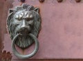 old metal lion knock door on grunge red wall background. Royalty Free Stock Photo