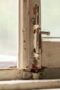 Old metal lock on a white wooden window frame. Old wooden window frame with a small rusty lock. Royalty Free Stock Photo