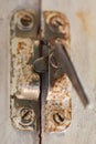 Old metal lock on a white wooden window frame. Old wooden window frame with a small rusty lock. Royalty Free Stock Photo