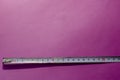 An old metal measuring tape on pink background Royalty Free Stock Photo