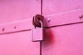 An old metal pink door locked with a padlock in order not to enter Royalty Free Stock Photo