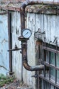 Old metal pipes with valves and a manometer Royalty Free Stock Photo