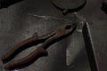 Old metal pliers for welding. Old iron pliers on a dirty metal table, slightly rusty