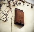 Old metal post box for mail hanging on white plaster dirty wall