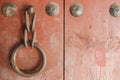 Old metal ring handle on red wooden door