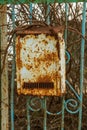 Old metal rusty mailbox, letterbox. Vintage vintage box for paper traditional letters hanging on a rusty iron fence