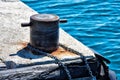 Old metal rusty mooring bollard with chain wrapped around. Royalty Free Stock Photo