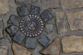 Old metal sewer hatch in the middle of the road, laid out of a smooth paving stone Royalty Free Stock Photo