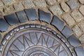 Old metal sewer hatch in the middle of the road, laid out of a smooth paving stone Royalty Free Stock Photo