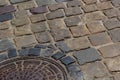 Old metal sewer hatch in the middle of the road, laid out of a smooth paving stone Royalty Free Stock Photo