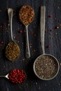 Old metal spoons with different kind of seeds and spices on black background Royalty Free Stock Photo