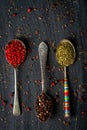 Old metal spoons with different kind of spices on black background Royalty Free Stock Photo