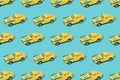 Old metal sport car toy yellow and blue color on blue background. Minimal design. Pattern