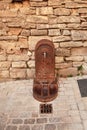 Old metal street water tap near sandstone wall. Element of urban improvement in Barjac, France