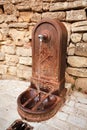 Old metal street water tap near sandstone wall. Element of urban improvement in Barjac, France