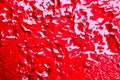 Old metal surface painted with fresh paint. Traces of water and green leaves of plants on a red background. Royalty Free Stock Photo