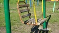 Old metal swing for children. carousel is moving. Empty abandoned city with a playground.