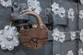 The old metal wrought-iron door is locked with a padlock. Closed metal lock. Royalty Free Stock Photo