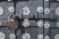 The old metal wrought-iron door is locked with a padlock. Closed metal lock. Royalty Free Stock Photo